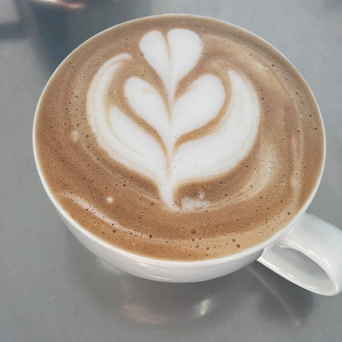 A freshly prepared A Pagnotta latte with floral latte art